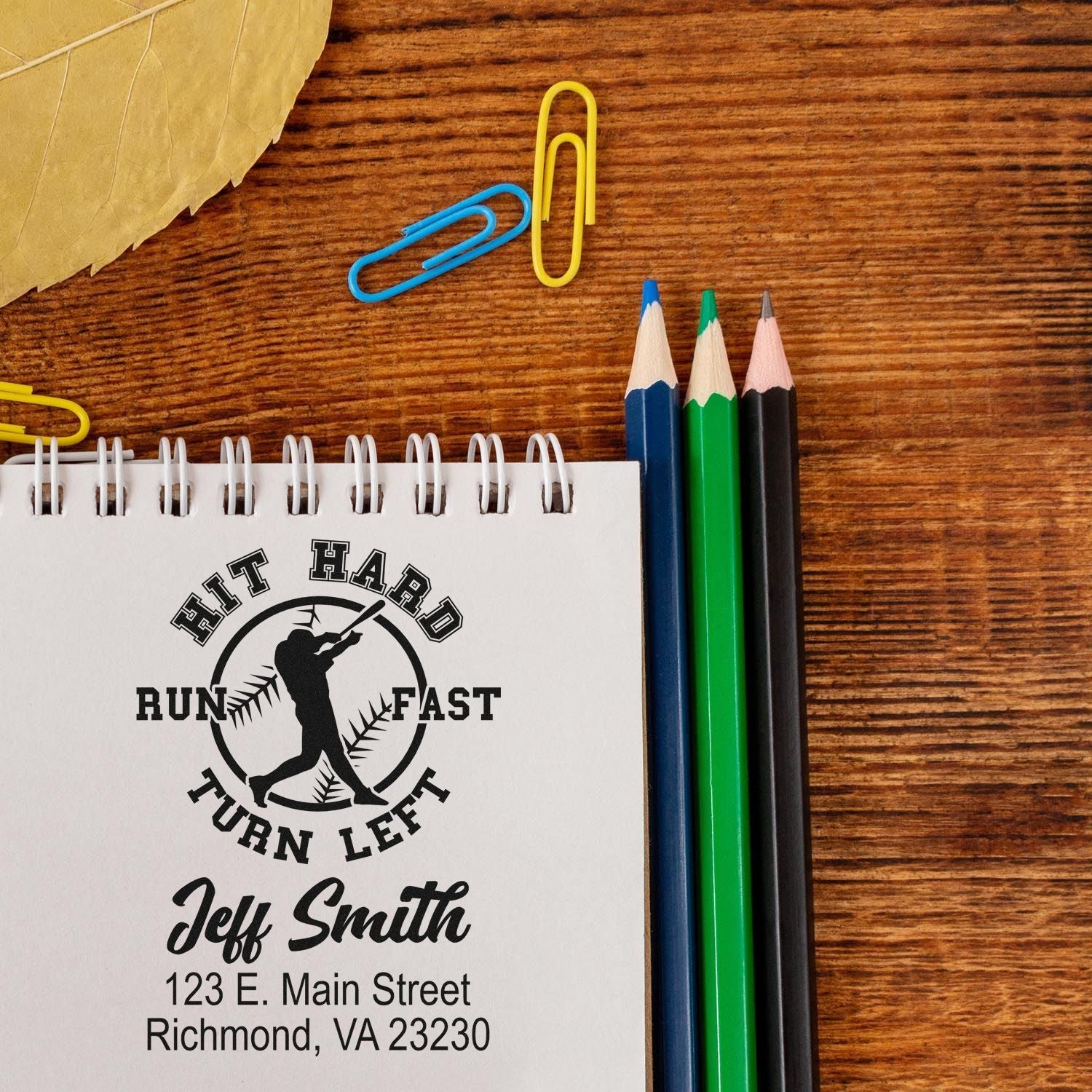Custom baseball rubber stamp with Hit Hard Run Fast Turn Left design and Jeff Smith return address on a notebook.