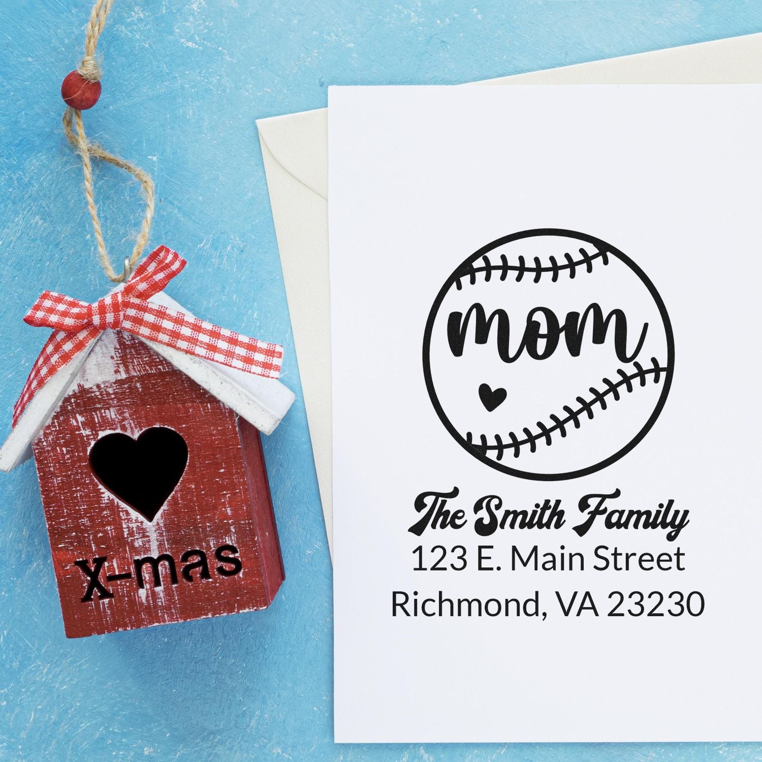 Personalized baseball mom address rubber stamp with family name and address, shown on a card beside an envelope.