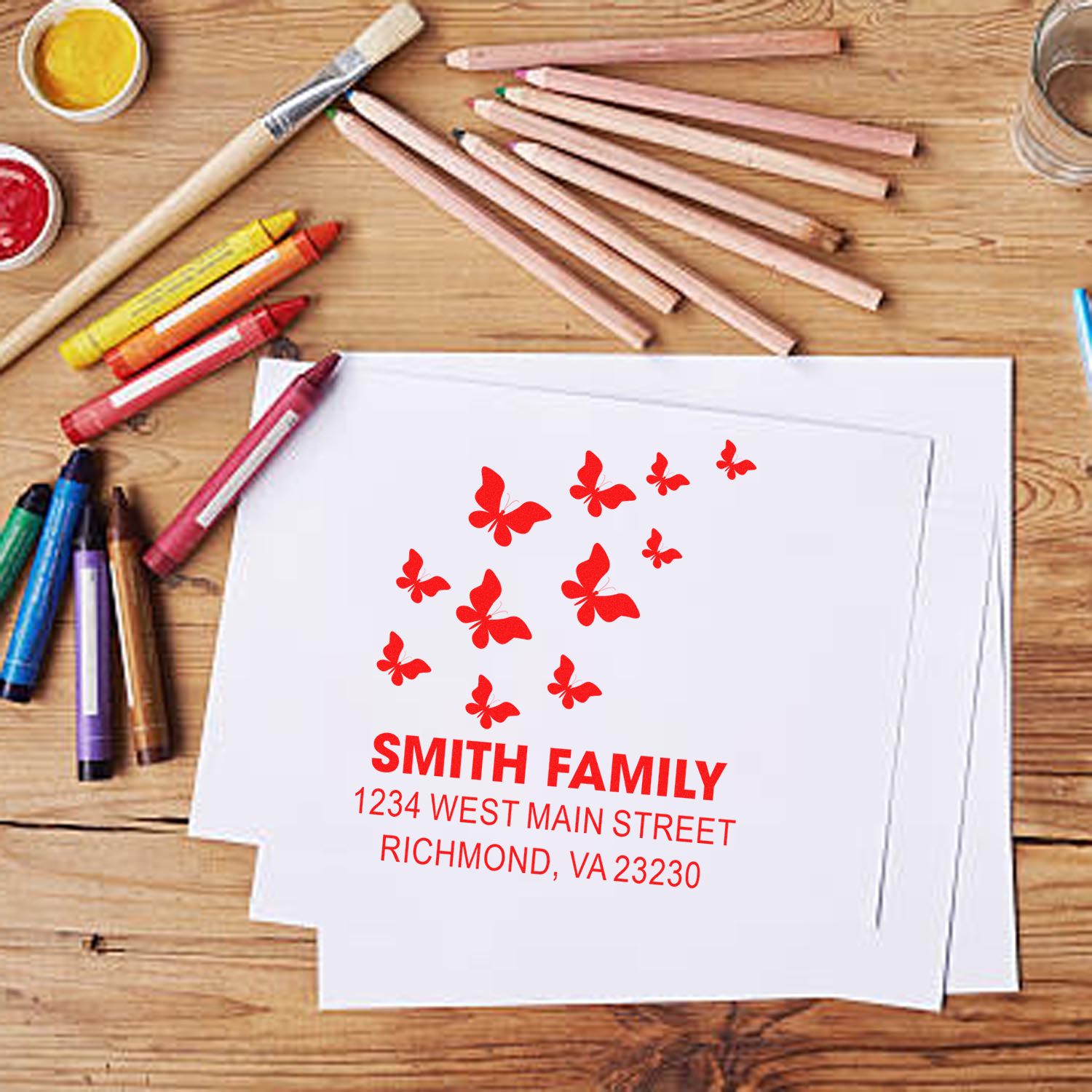 Personalized rubber return address stamp with butterfly design and Smith Family address on envelope.