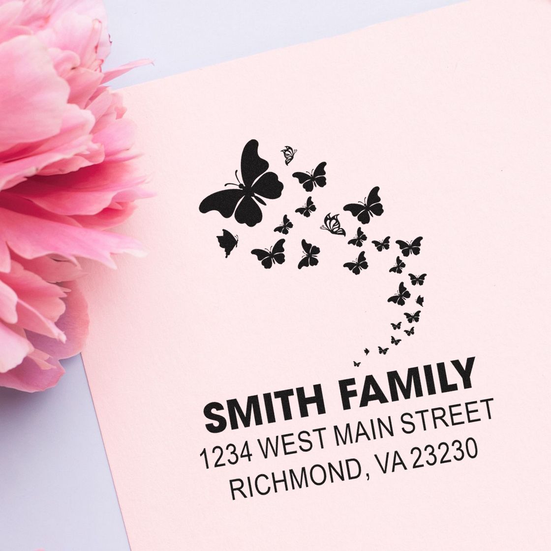 Custom butterfly address rubber stamp with Smith family name and Richmond, VA return address on pink stationery.