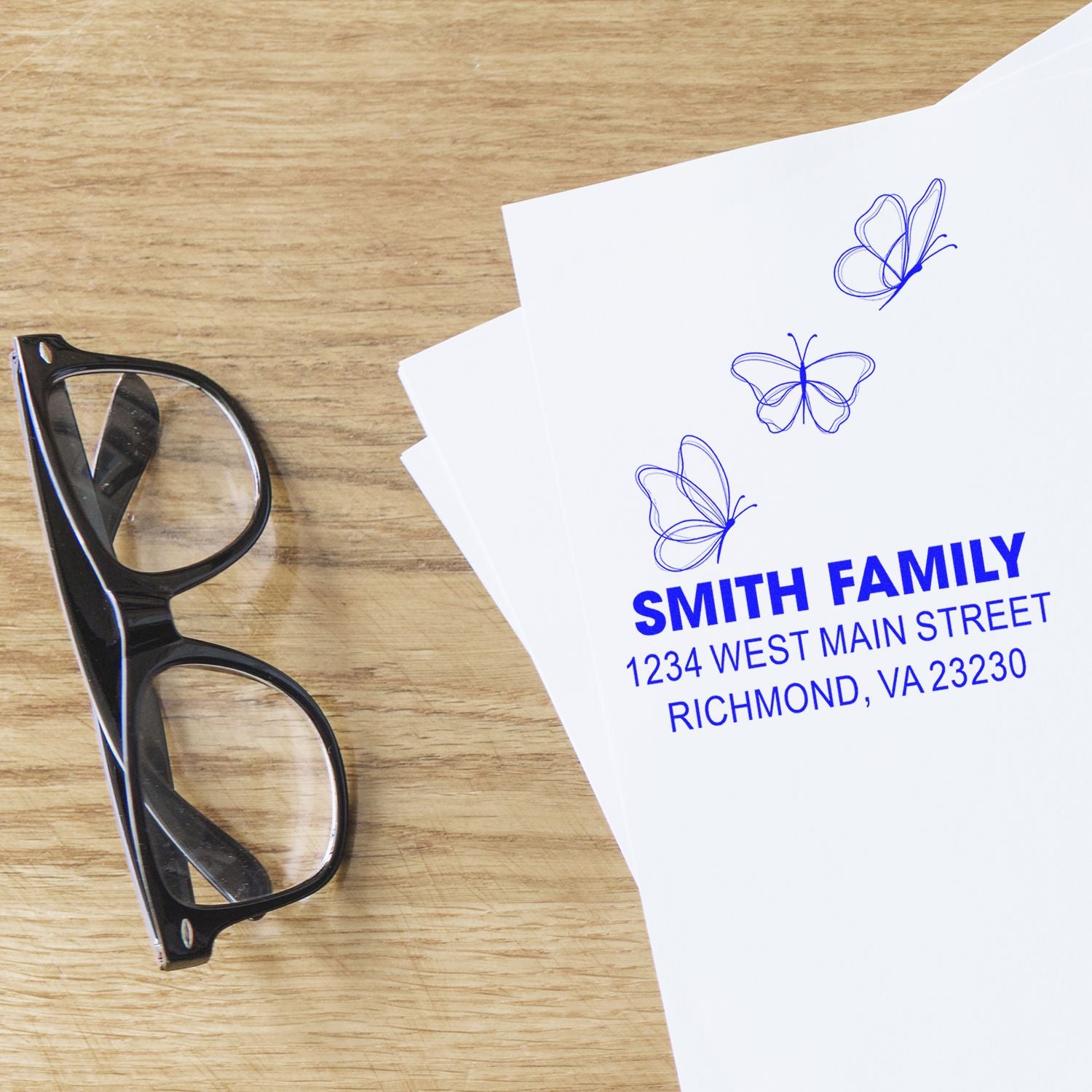 Personalized butterfly address rubber stamp on white paper, showing Smith Family name and Richmond, VA return address.