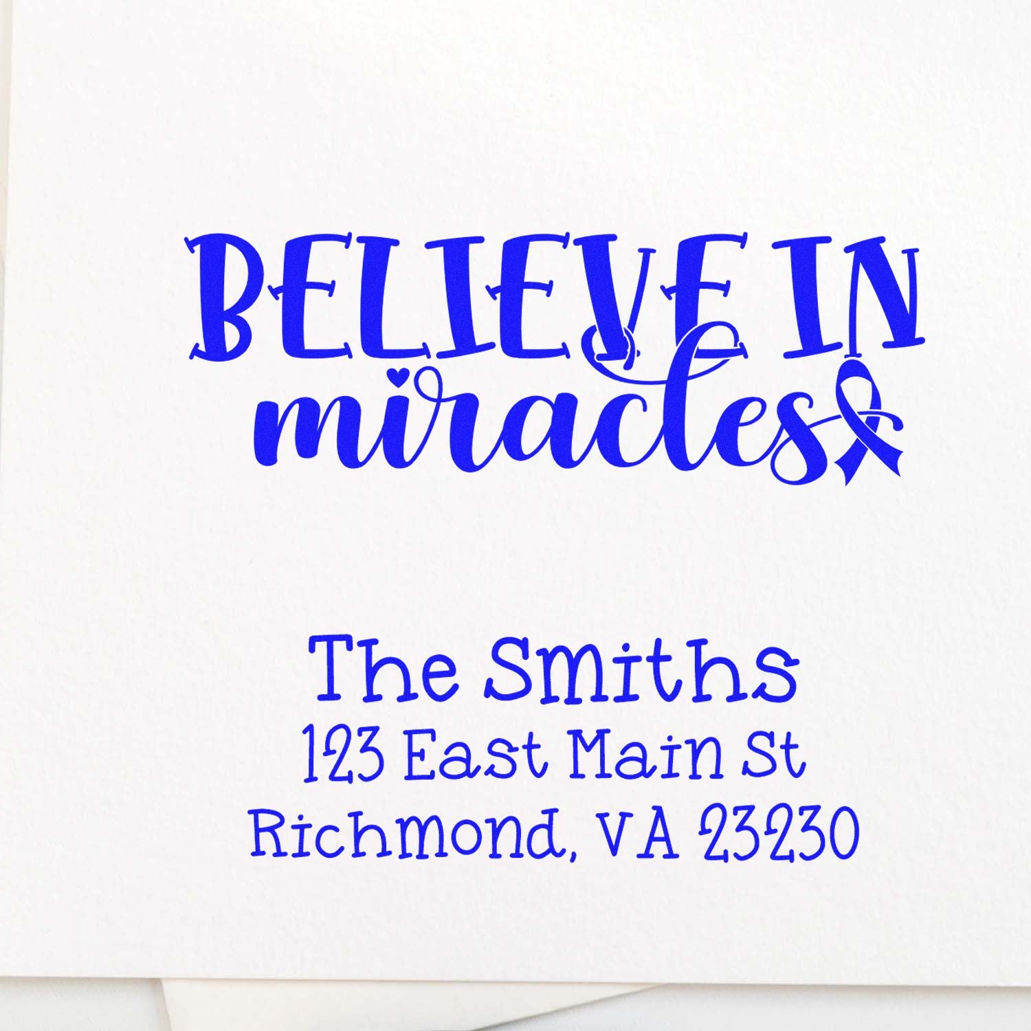 Custom return address rubber stamp with blue Believe in Miracles text and The Smiths, Richmond, VA 23230.