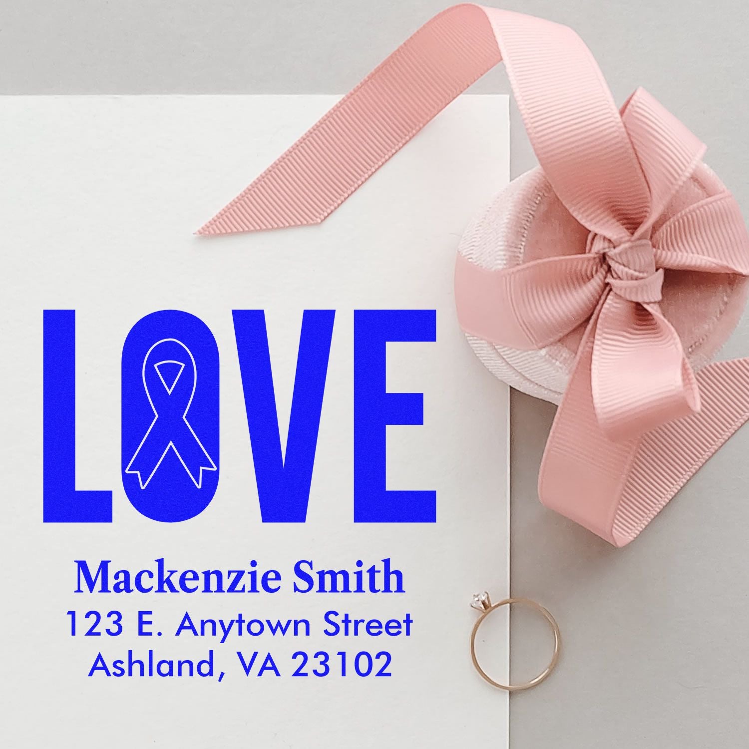 Custom rubber stamp for wedding invitations, featuring LOVE, pink ribbon bow, and personalized name and address.