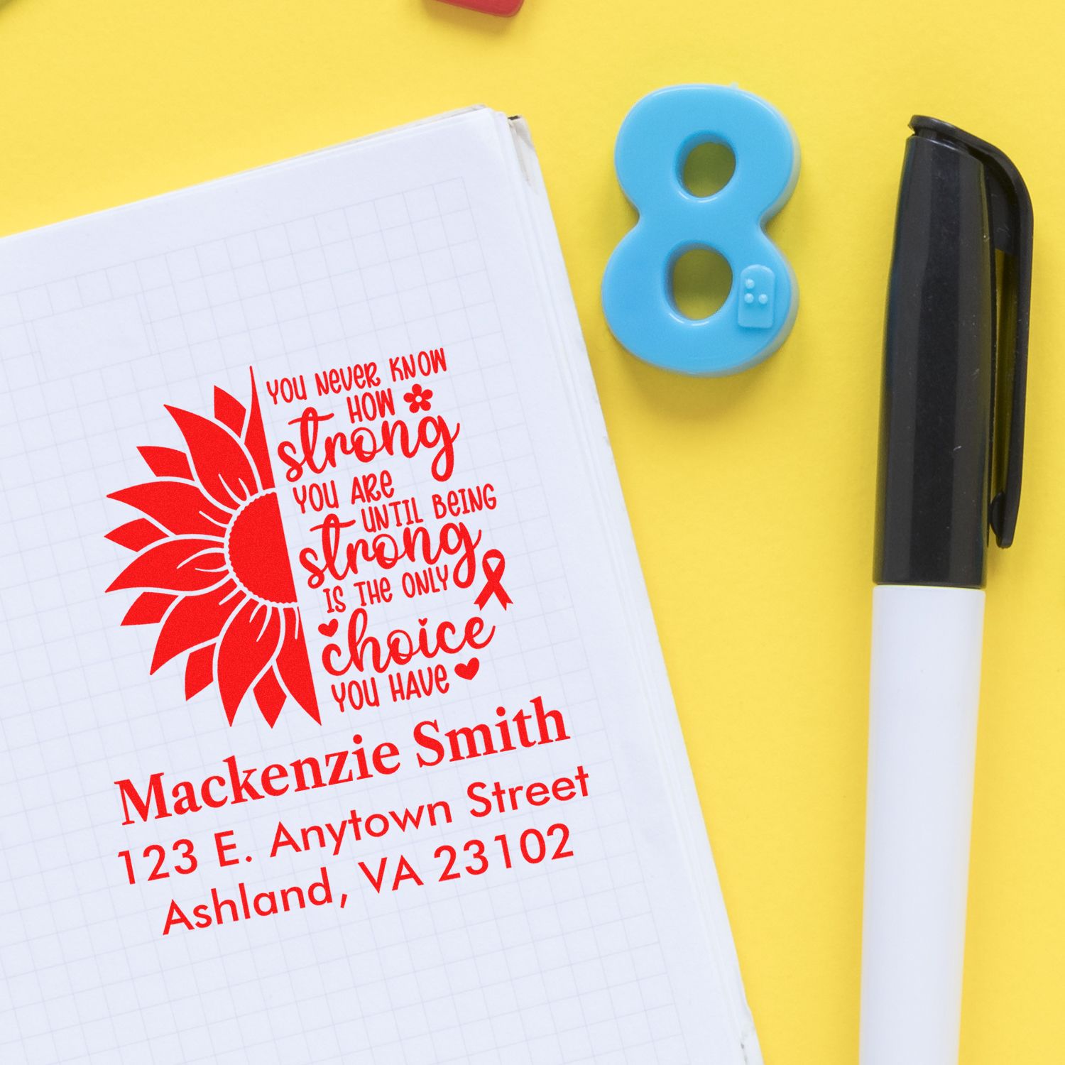Personalized rubber stamp impression with sunflower quote, name, and address on a notebook for custom stationery.