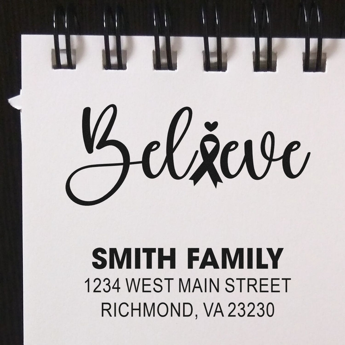 Custom rubber stamp design with Believe ribbon, Smith Family name, and address for personalized envelopes and stationery.