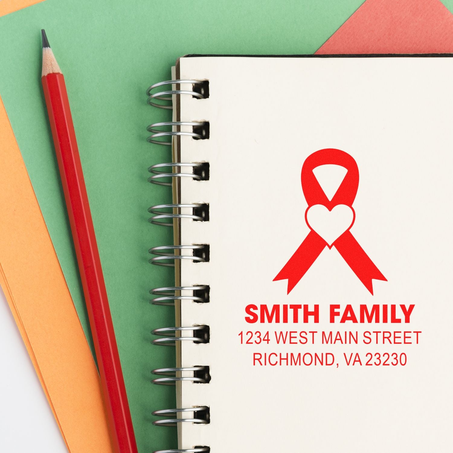 Custom return address rubber stamp with red ribbon logo on spiral notebook, personalized for the Smith family.