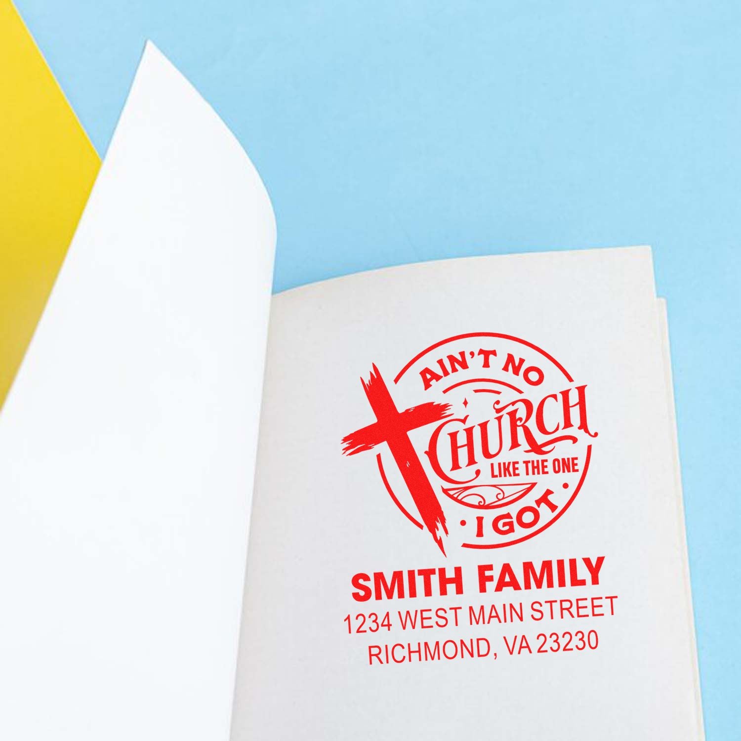 Red custom church rubber stamp for Smith Family with name and address on a booklet page.