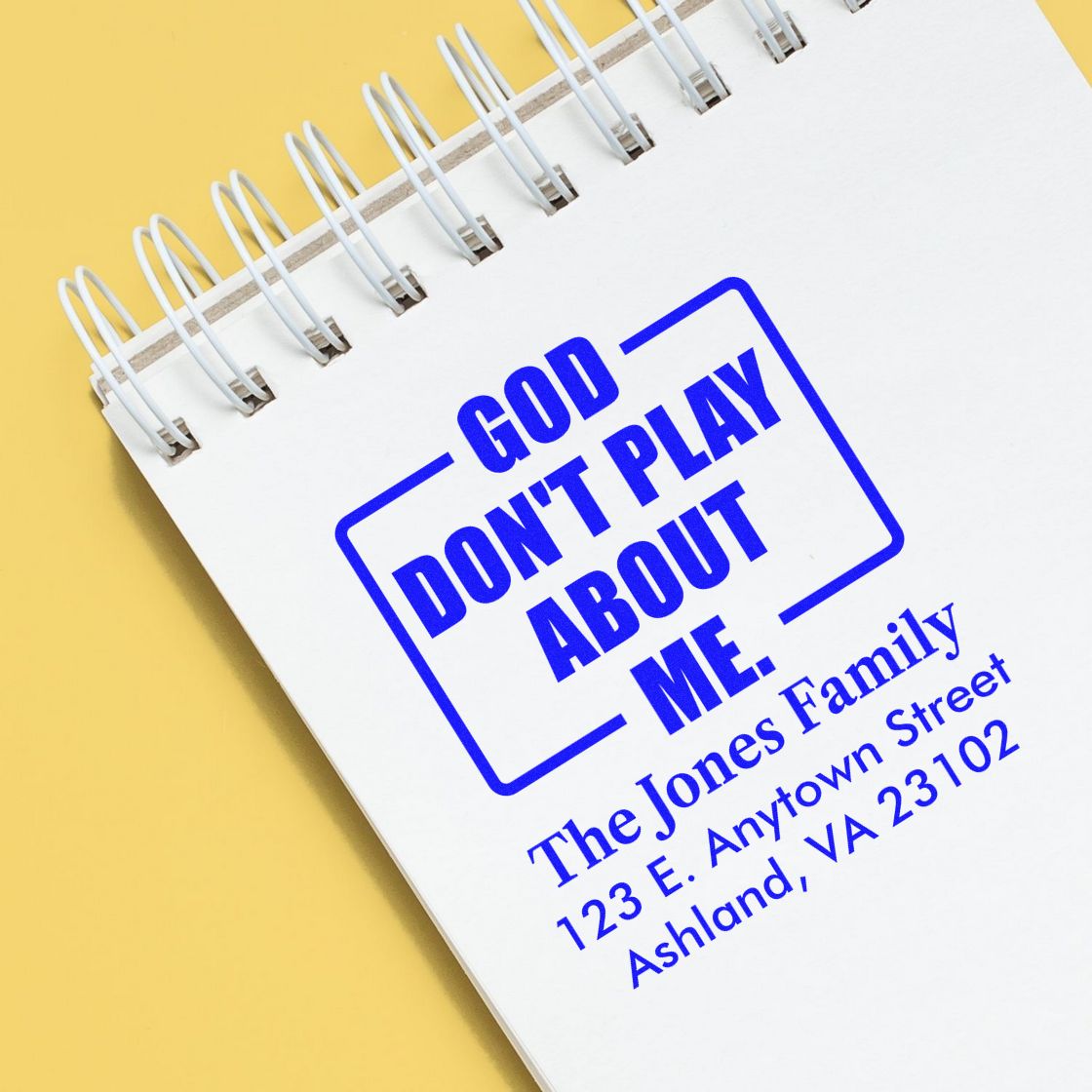 Custom rubber stamp impression with God Dont Play About Me and family address on notebook for personalized mailing.
