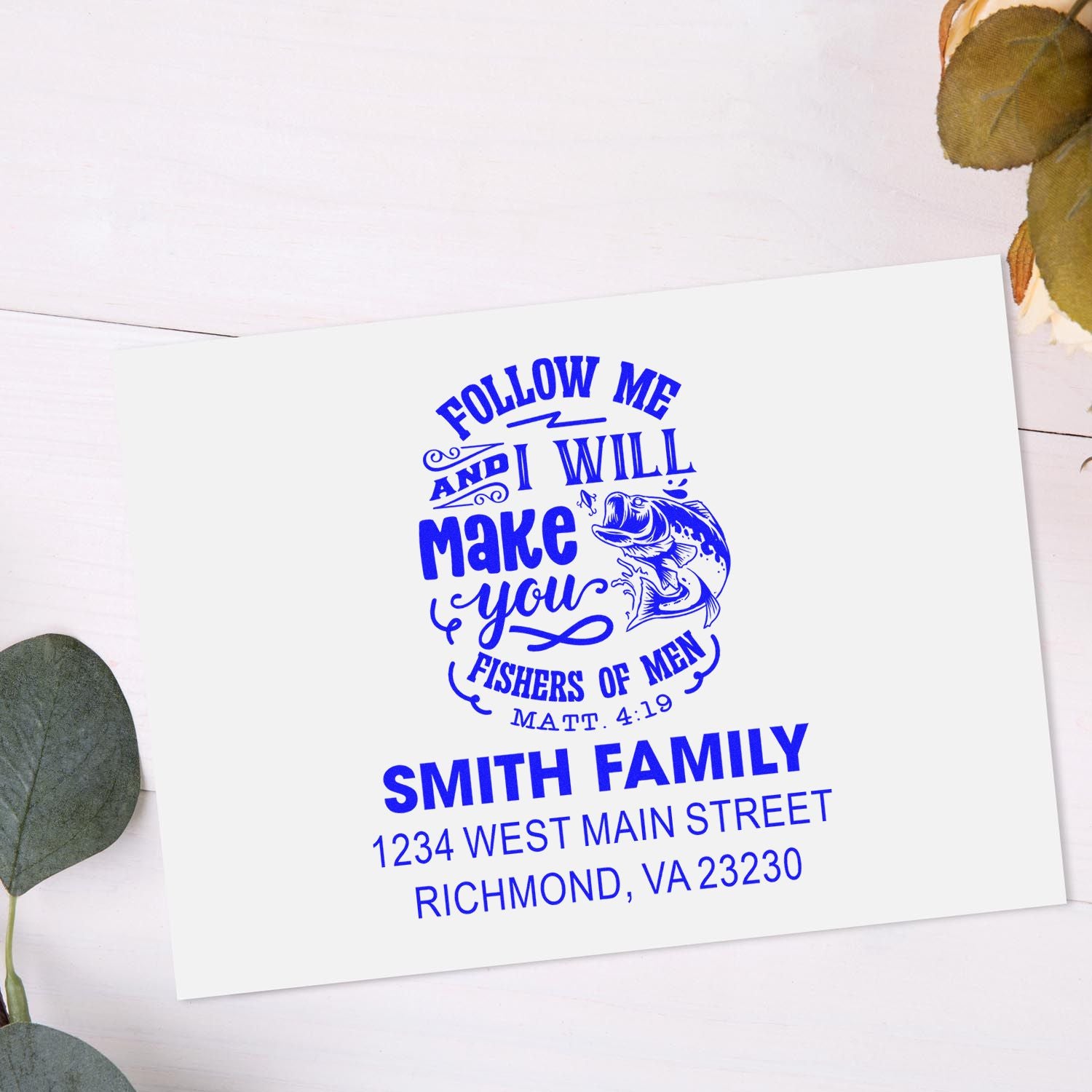 Personalized faith-based rubber stamp with Bible verse, fish graphic, family name, and address in blue ink.