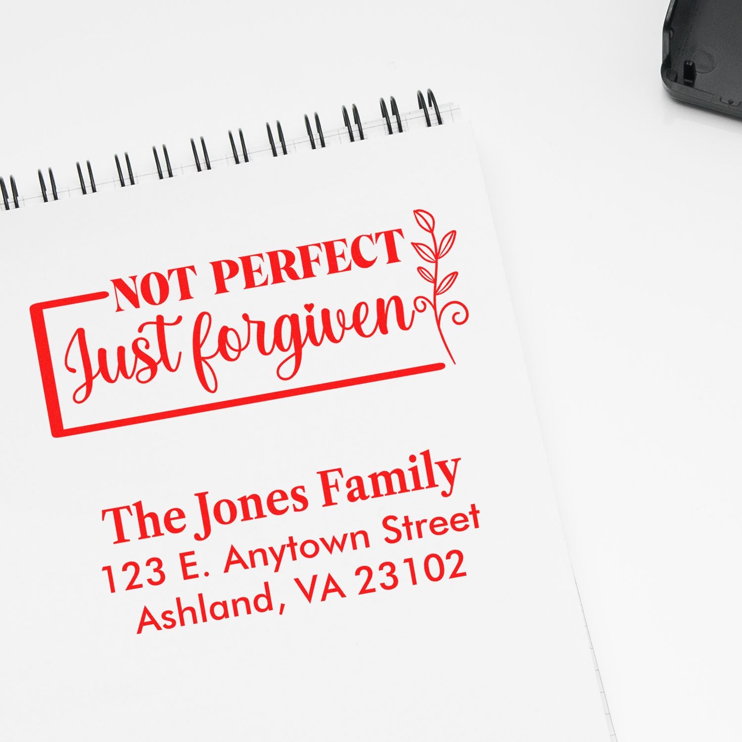Custom rubber stamp sample showing a red Not Perfect, Just Forgiven design and personalized return address stamp.