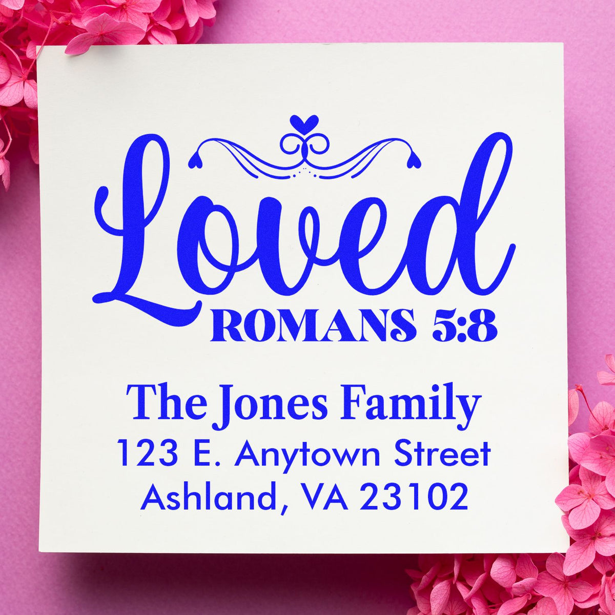 Personalized Christian rubber stamp with Loved Romans 5:8 and family address for faith-based stationery.