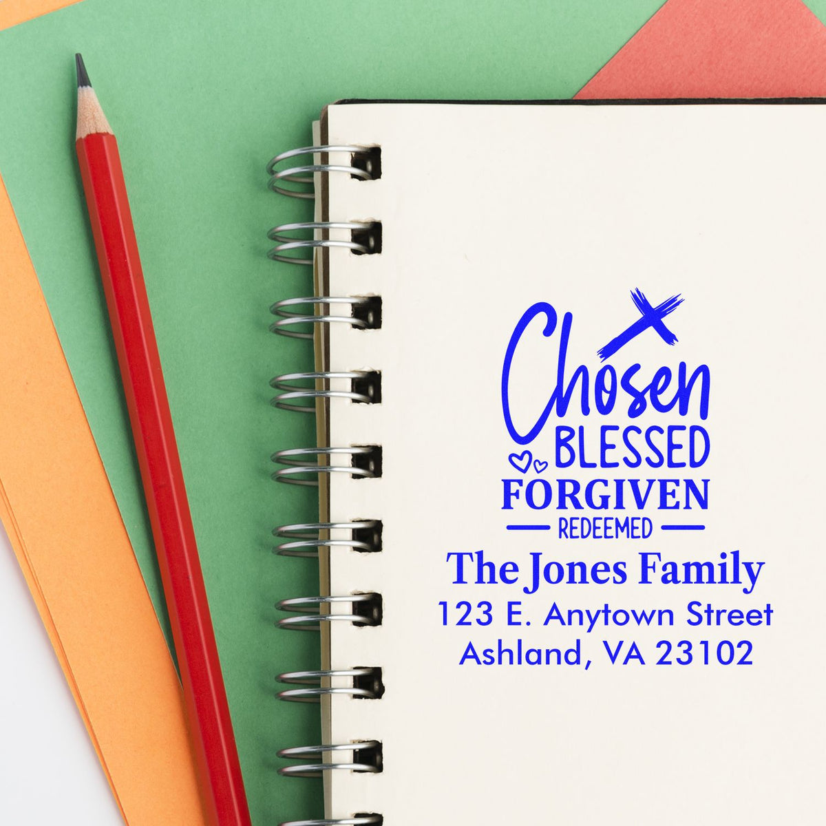 Christian family address rubber stamp with Chosen, Blessed, Forgiven, Redeemed design on a spiral notebook.
