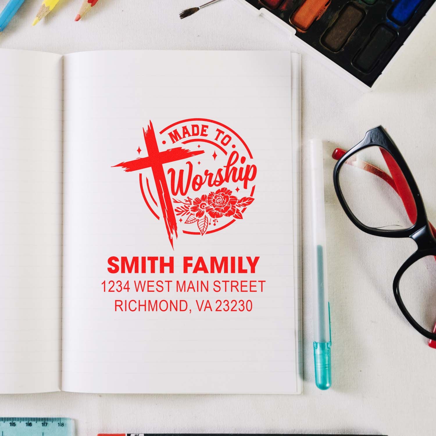 Custom rubber stamp mockup with Made to Worship cross logo, Smith Family name, and Richmond, VA address on a notebook.