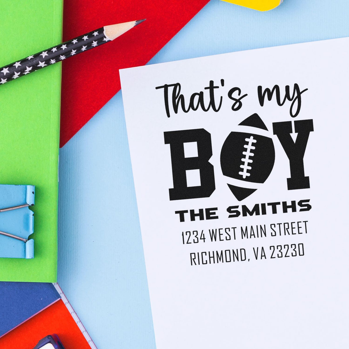 Custom football-themed rubber stamp design with Thats my boy message, family name, and address for personalized stationery.