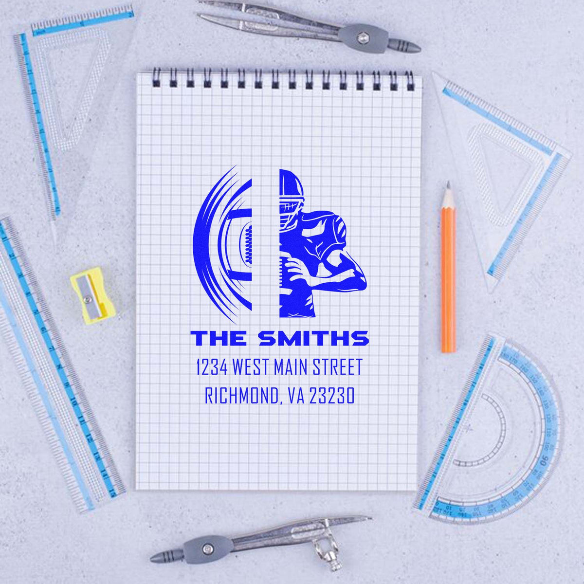 Custom address rubber stamp design for The Smiths, Richmond VA, shown on a notebook with drafting tools.
