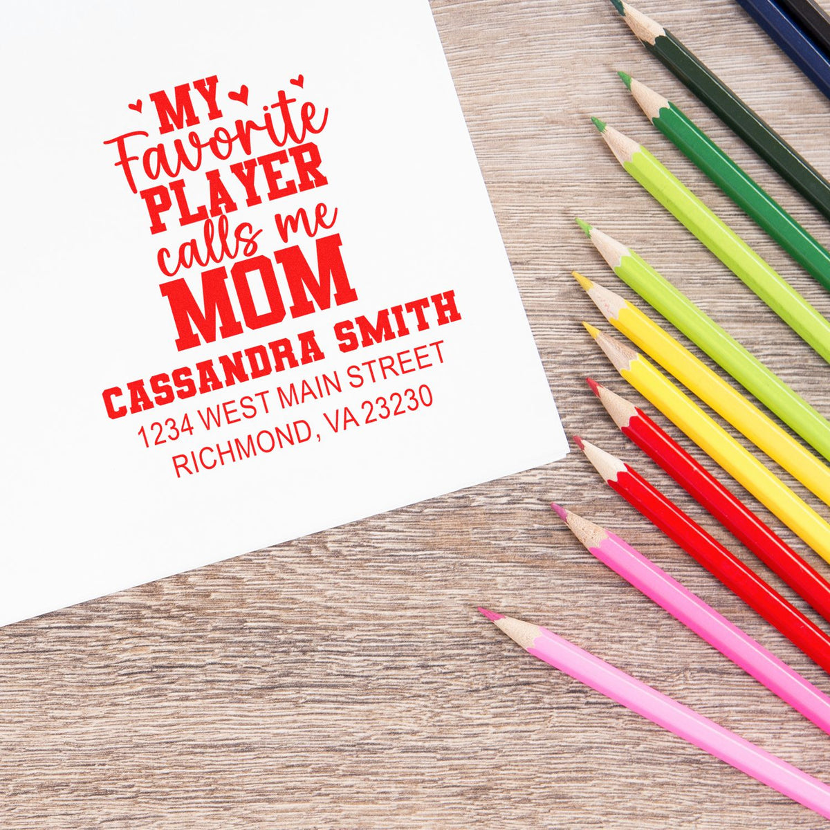 Custom rubber stamp design for Mom with personalized name and address, displayed beside colorful pencils.