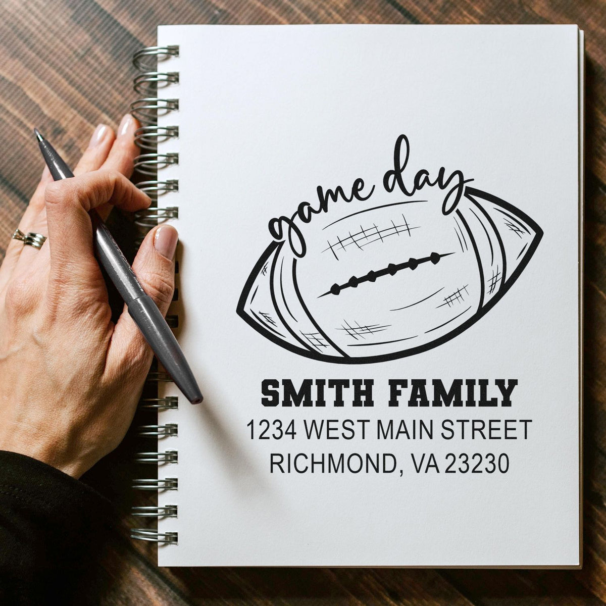 Custom football game day rubber stamp with Smith Family name and address on a spiral notebook.