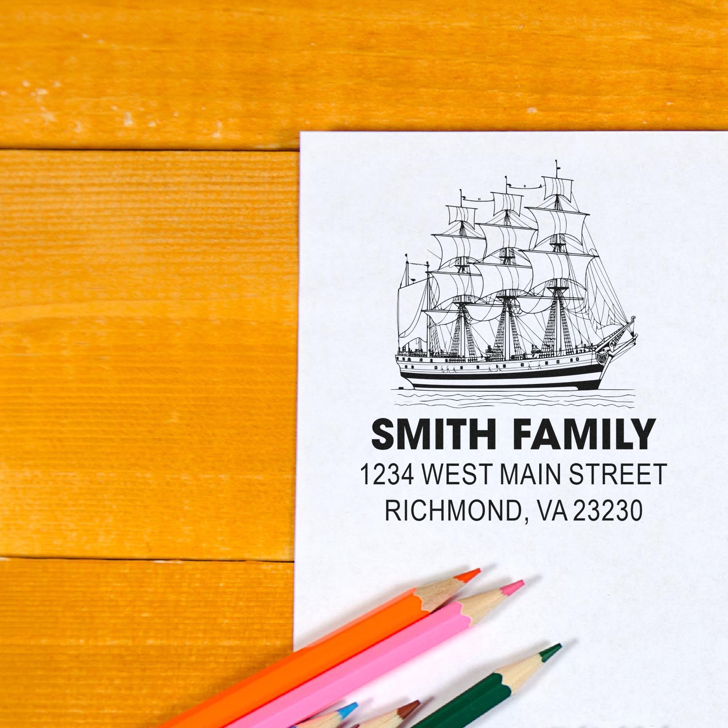 Custom nautical family address rubber stamp with sailing ship design and personalized name and address on paper.