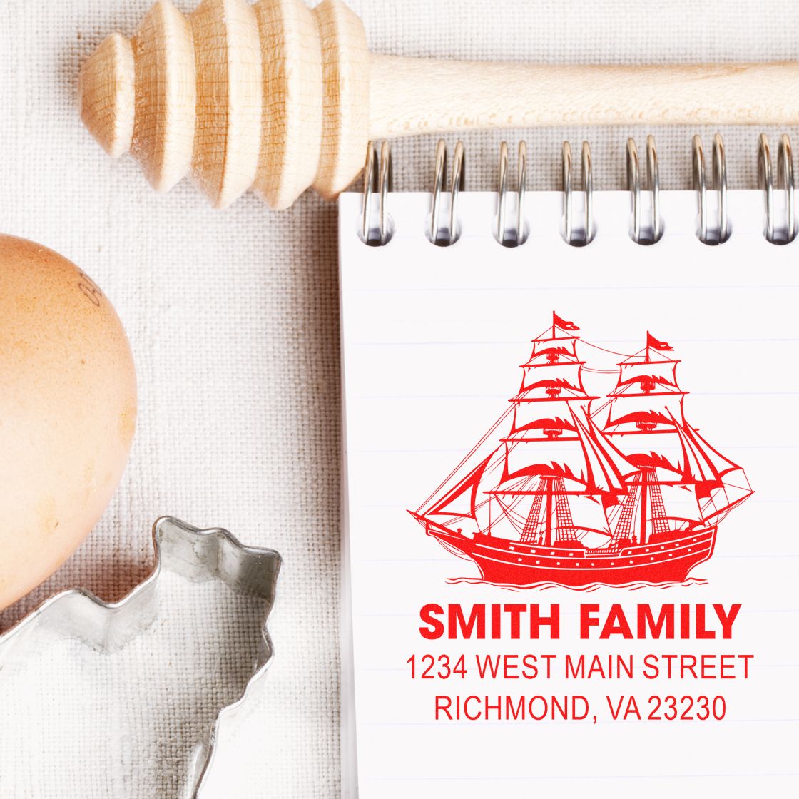 Custom family rubber stamp impression with ship design and address on notebook, showcasing a personalized address stamp.