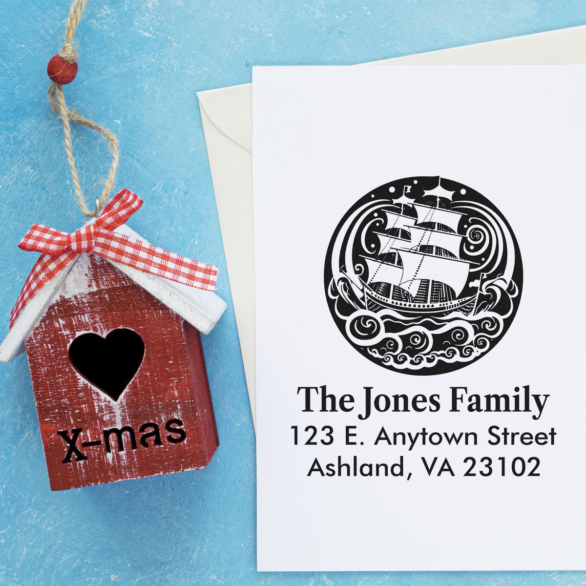 Custom family address rubber stamp with ship design, shown beside a handmade X-mas birdhouse ornament gift tag.