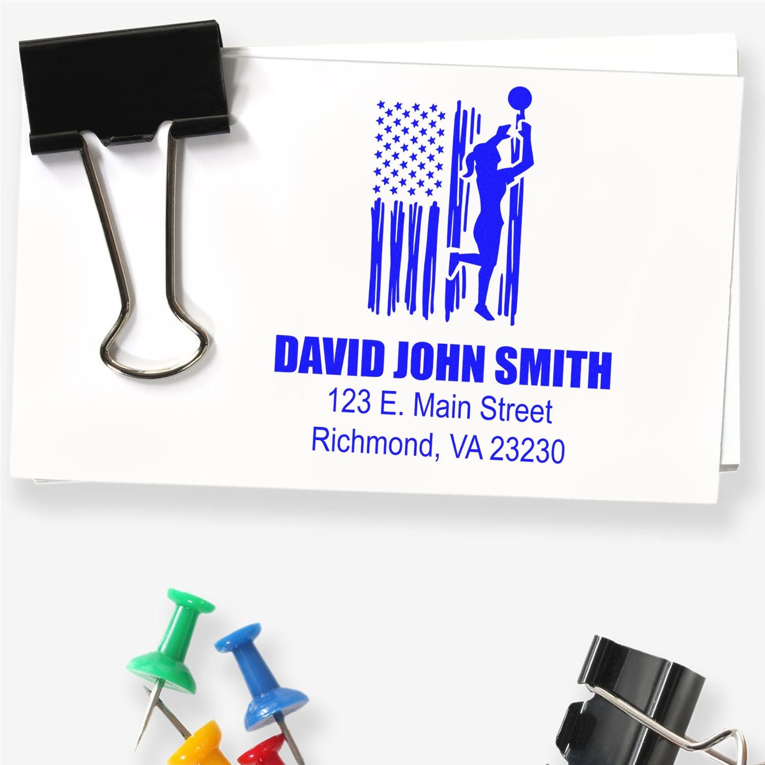 Custom rubber address stamp with name, street address, and Richmond VA imprint on paper, shown with binder clip