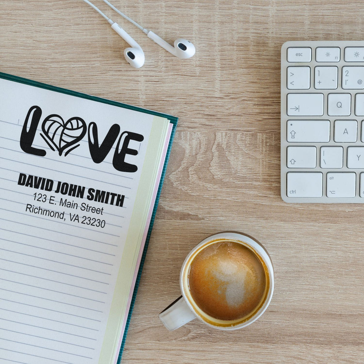 Personalized rubber stamp with love design and address imprint for custom stationery and mail on a desk.