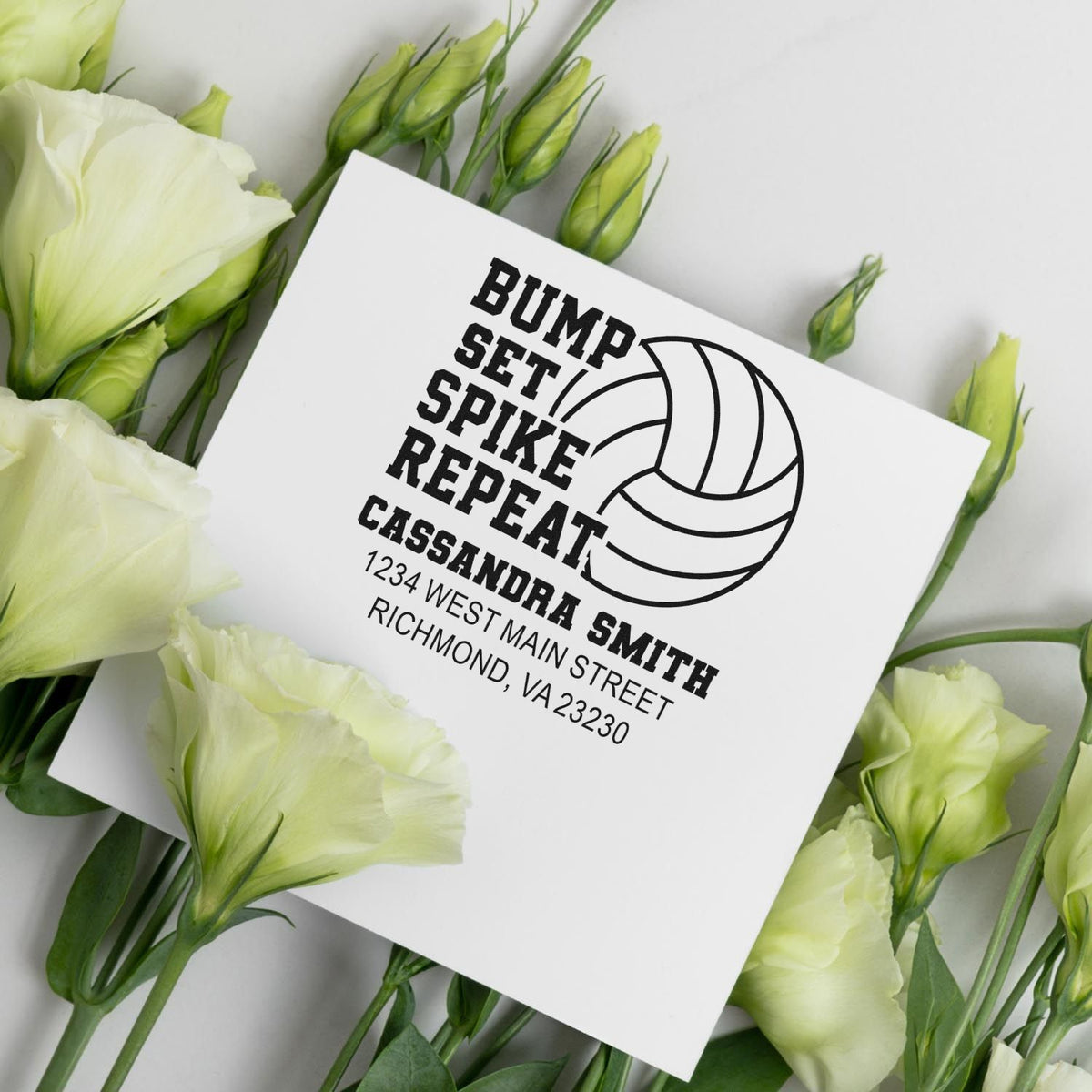 Personalized volleyball rubber stamp preview with team logo, name, and address on a white card with flowers.