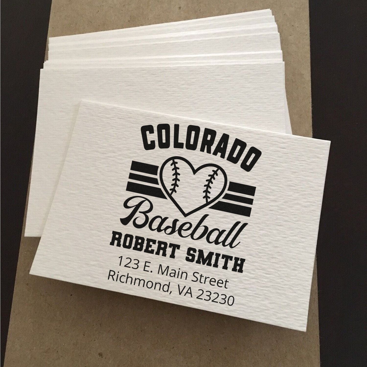 Custom baseball rubber stamp design with Colorado logo, name, and address on personalized white napkins.