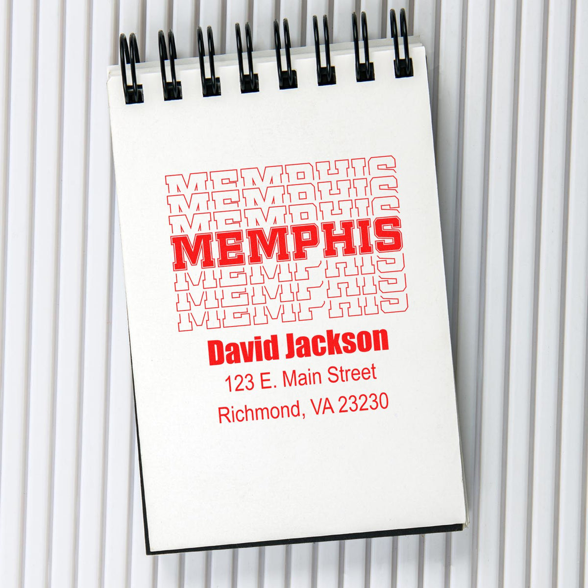 Personalized Memphis-style rubber stamp design with name and address on a notebook page.