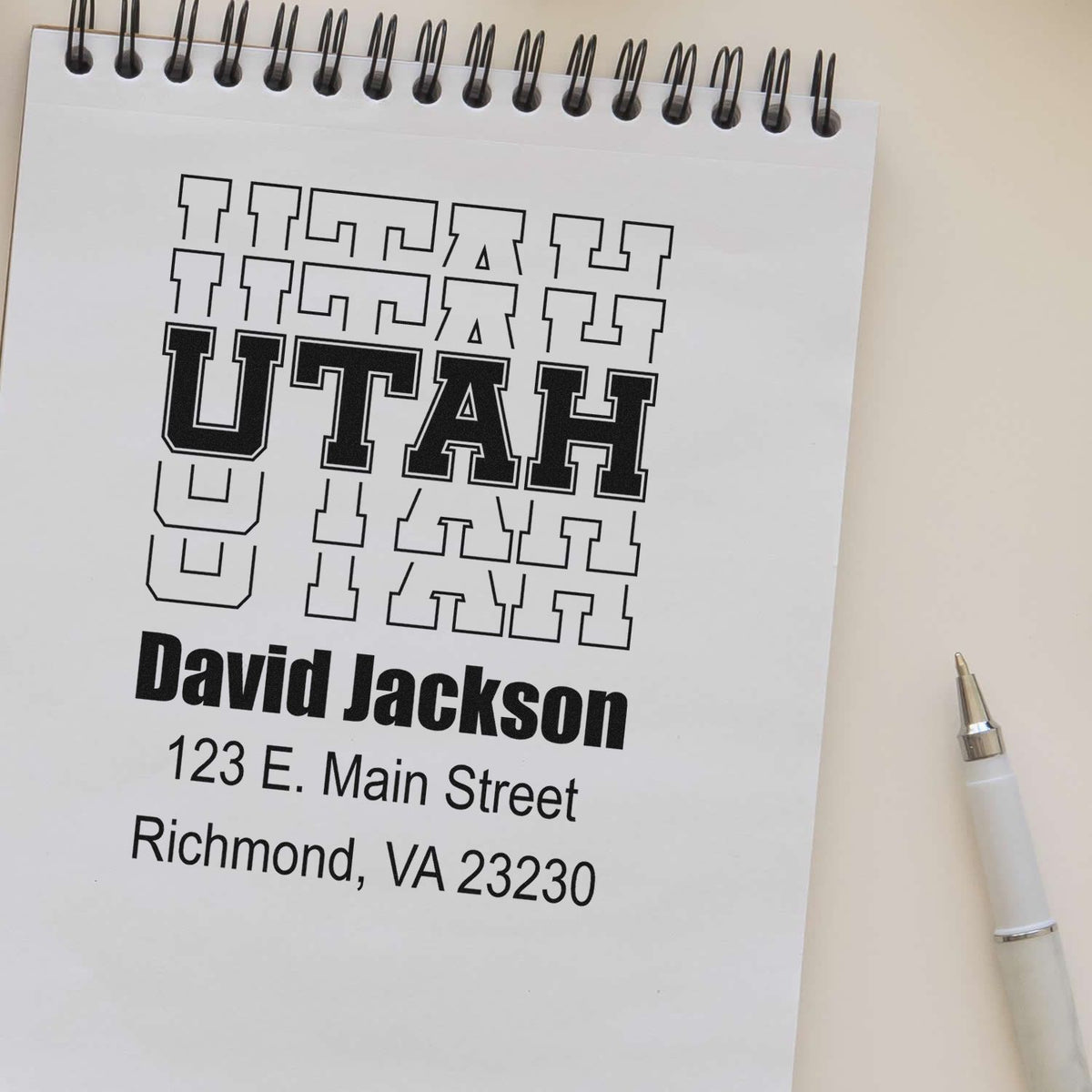 Custom Utah address rubber stamp proof with name and address layout on a spiral notepad.