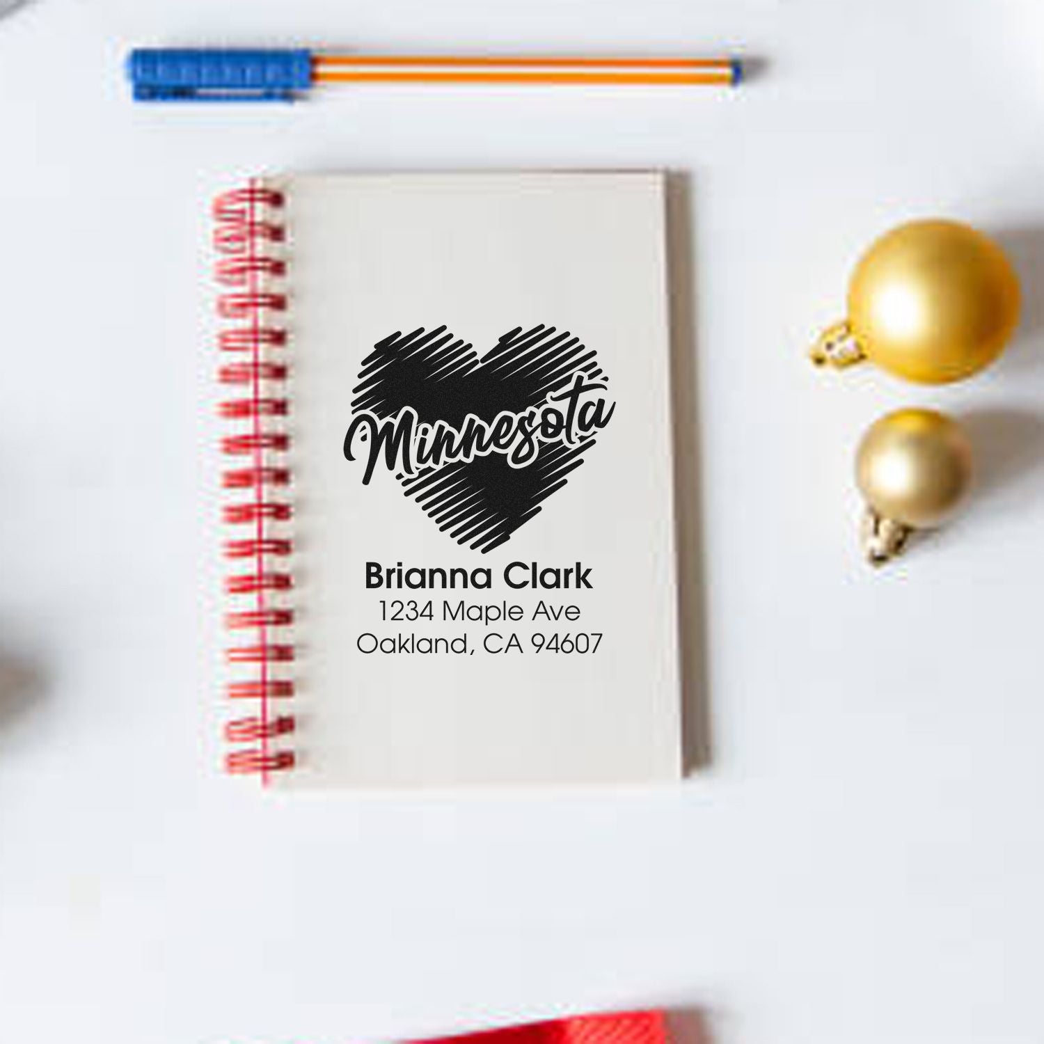 Custom Minnesota heart address rubber stamp design on notebook, personalized with name and mailing address.
