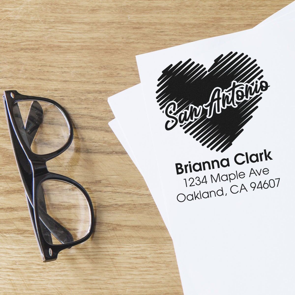 Custom return address rubber stamp with heart logo, name, and address for personalized stationery and mailings.