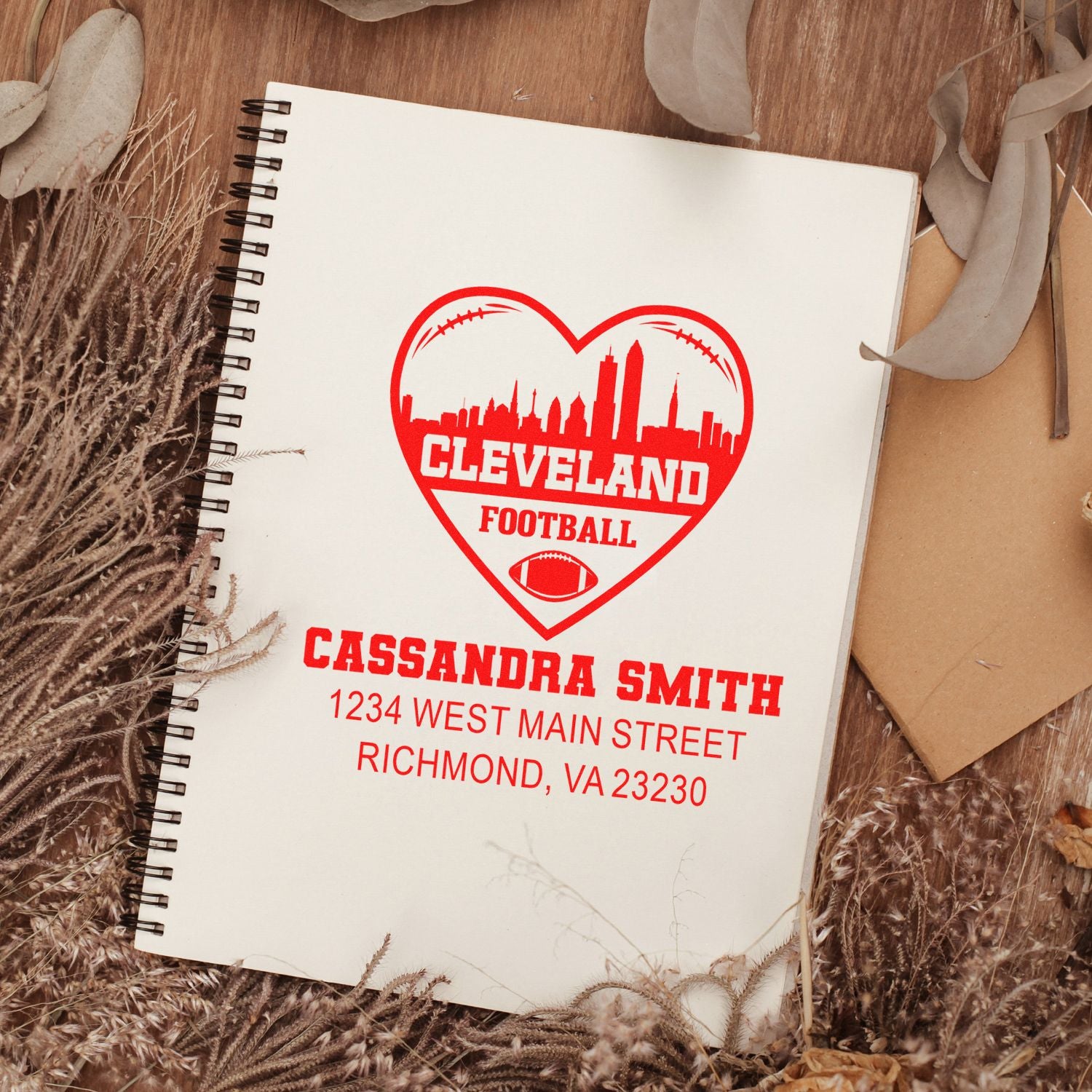 Personalized Cleveland football rubber stamp with heart skyline, name and address imprint on a spiral notebook.