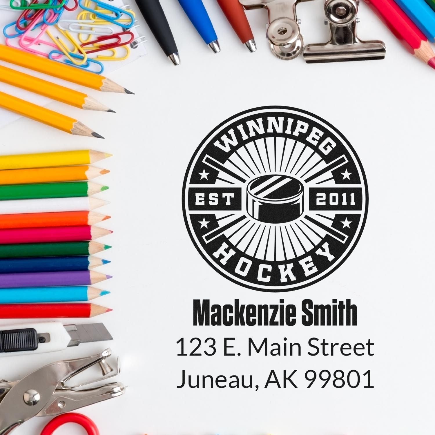 Custom hockey rubber stamp with Mackenzie Smith name and Juneau, AK return address, shown with stationery supplies.