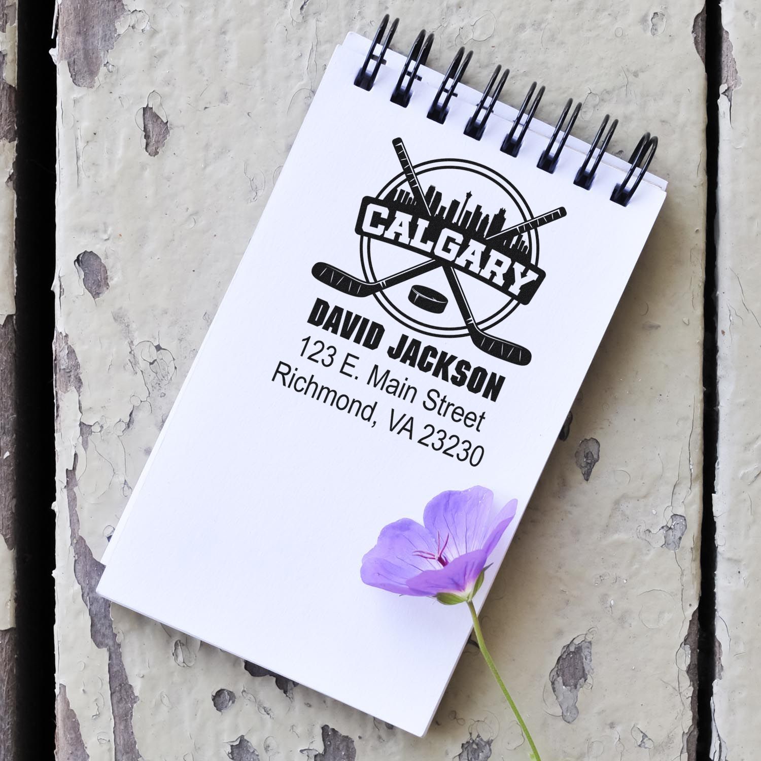 Custom Calgary hockey rubber stamp with logo, name, and address on a notepad for personalized mailing.
