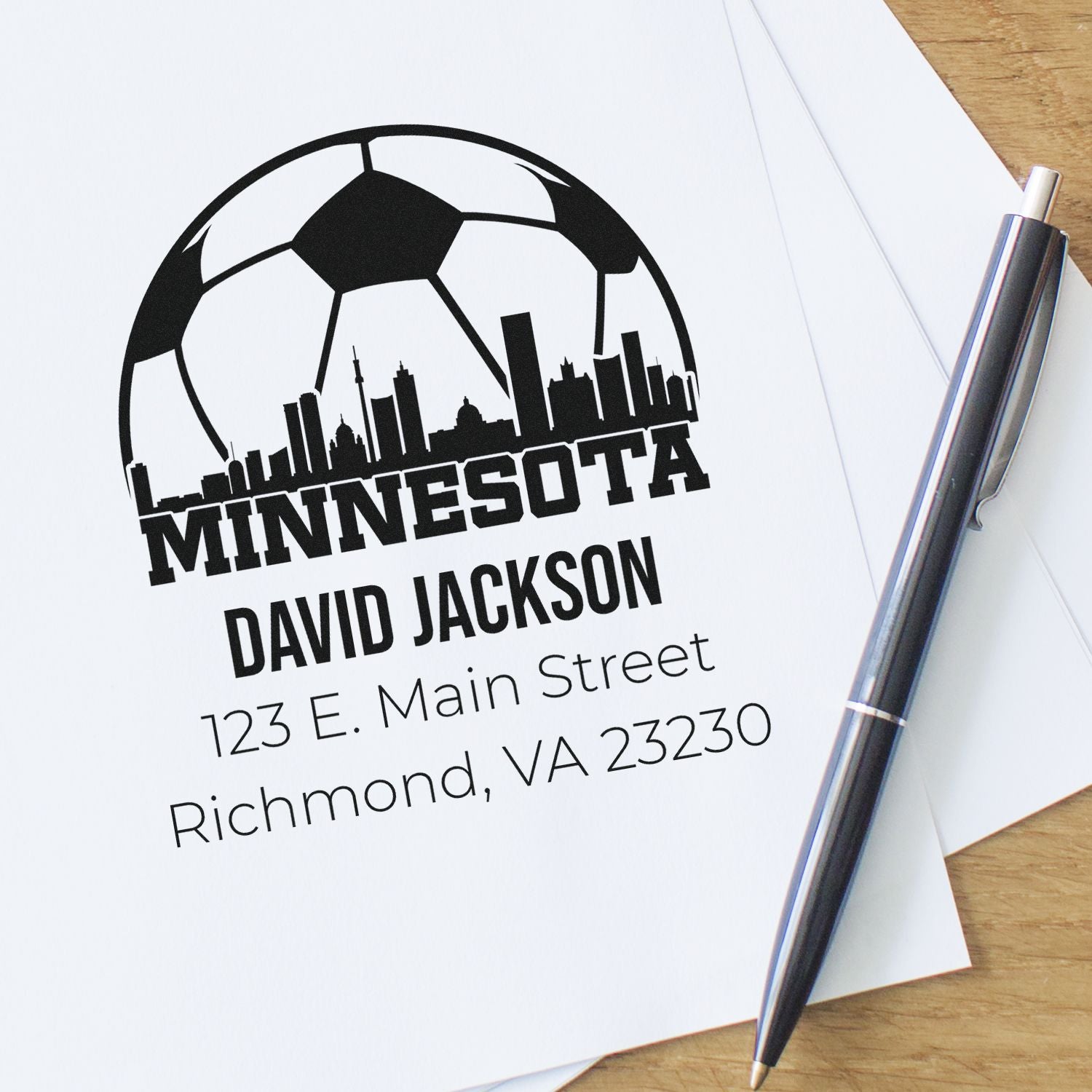 Custom Minnesota rubber stamp with soccer skyline logo, David Jackson name, and Richmond, VA address on paper.