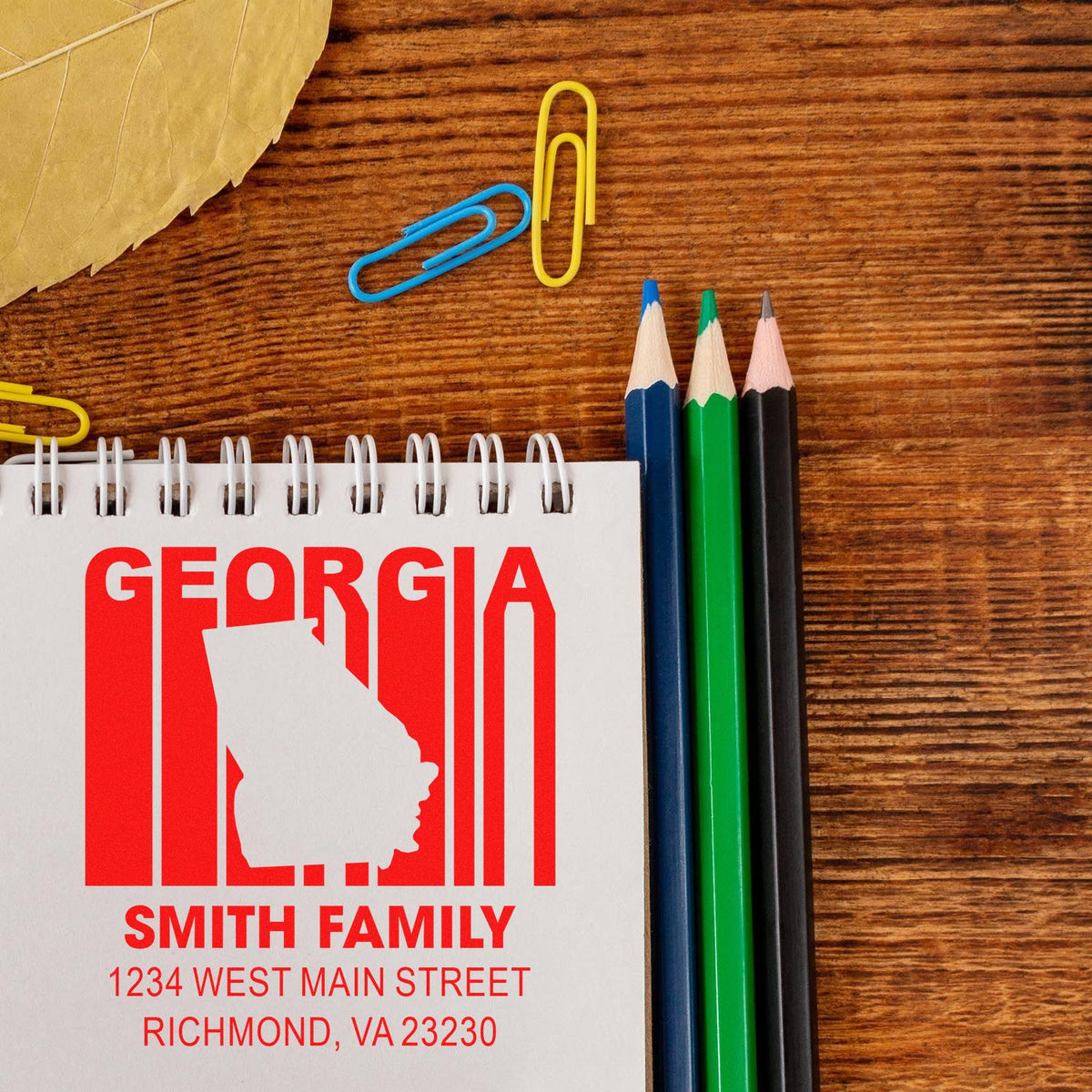 Custom Georgia family return address rubber stamp mockup on notebook with state silhouette and Richmond, VA address.