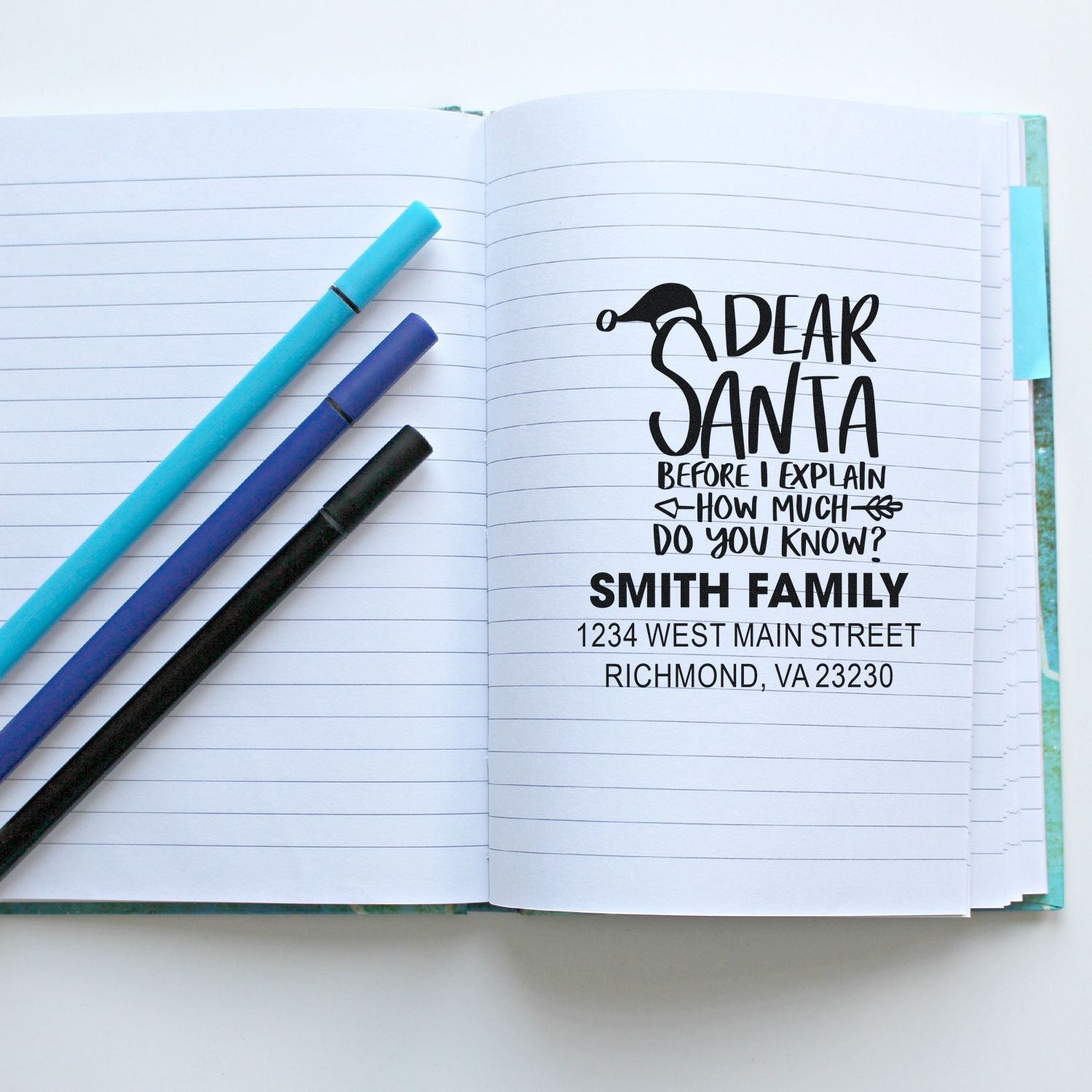 Custom Christmas return address rubber stamp impression in a notebook, featuring a Dear Santa quote and Smith family address.