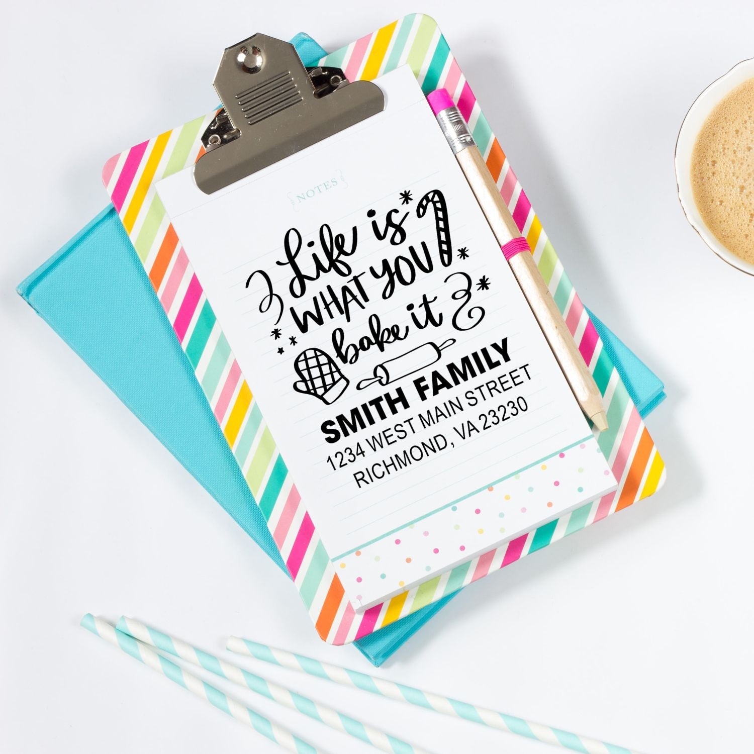 Personalized return address rubber stamp displayed on clipboard with bakery-themed note, custom family name and address.