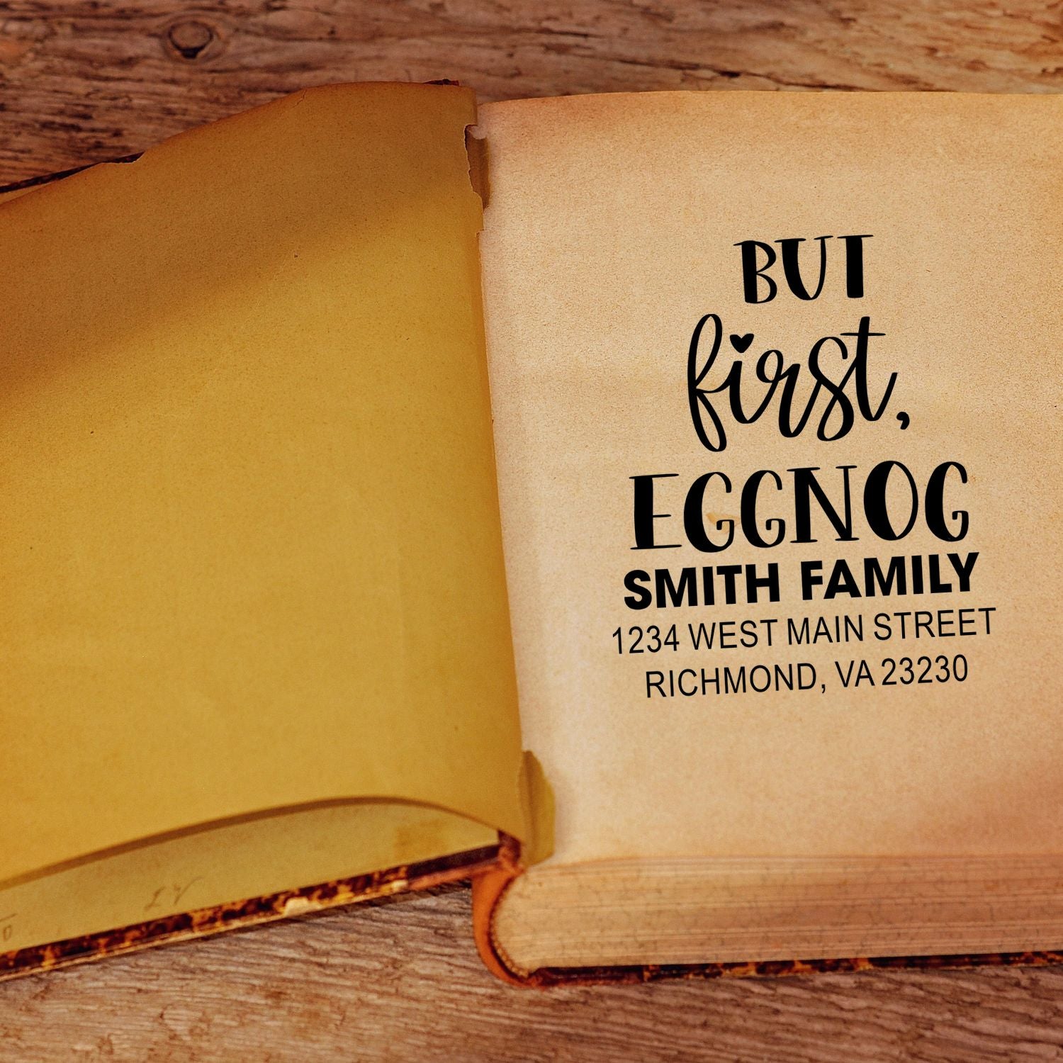 Personalized return address rubber stamp on book page with But first, eggnog Smith family address.