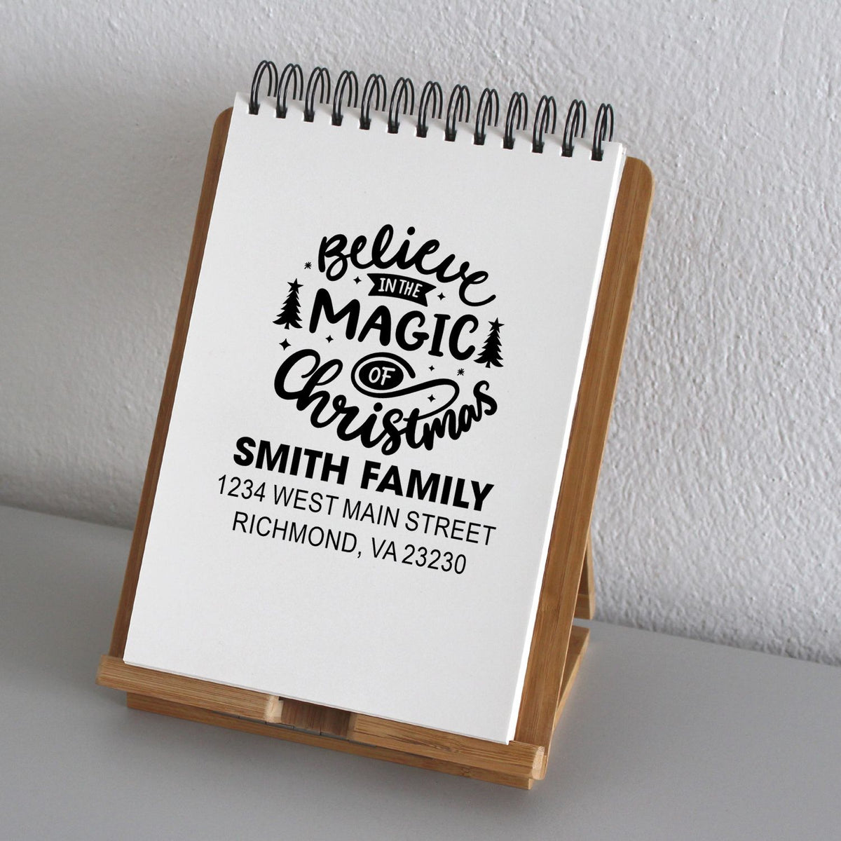 Custom holiday rubber stamp design reading Believe in the Magic of Christmas with family name and address.