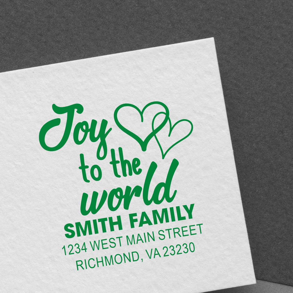 Custom rubber stamp with Joy to the World holiday message, hearts, and family return address for Christmas mail.