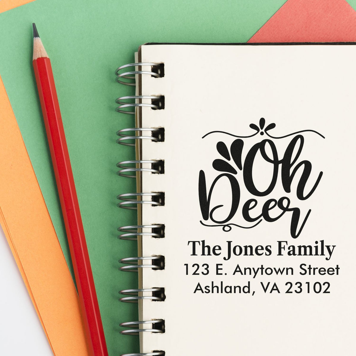 Custom return address rubber stamp with Oh Deer design for The Jones Family, Ashland, VA, on a spiral notebook.