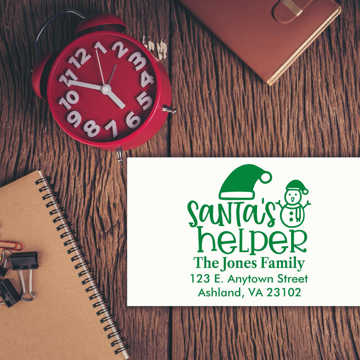 Custom Christmas rubber stamp with Santas Helper design, family name, and return address for holiday card mailing.