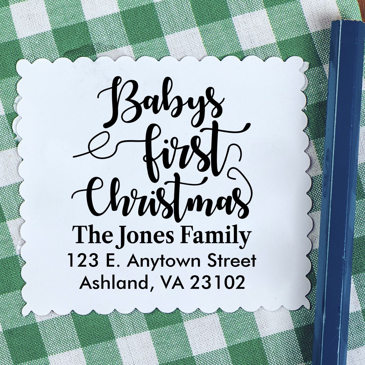 Personalized Babys First Christmas address rubber stamp with family name and address on scalloped paper.