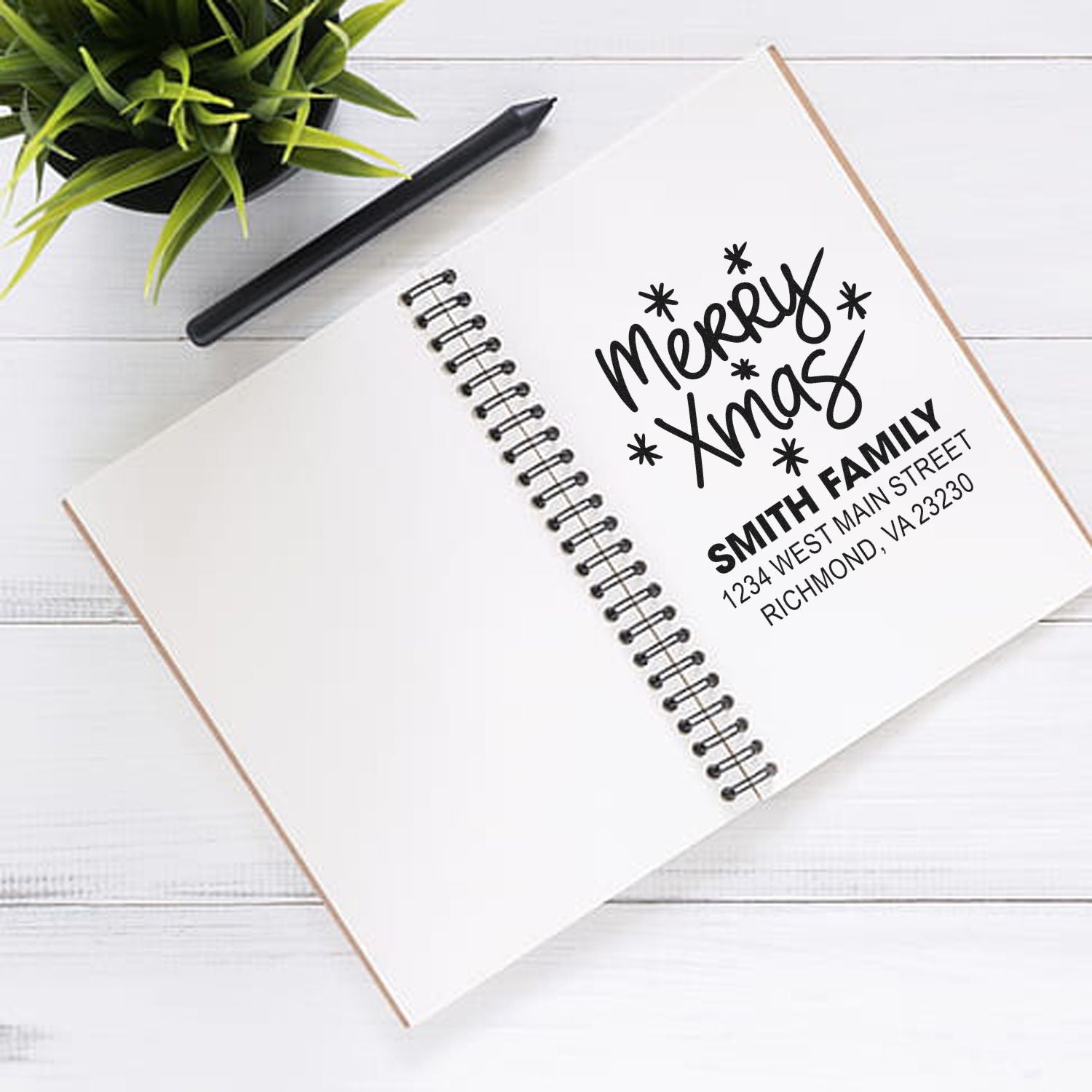 Custom rubber stamp with Merry Xmas and Smith family return address on a notebook