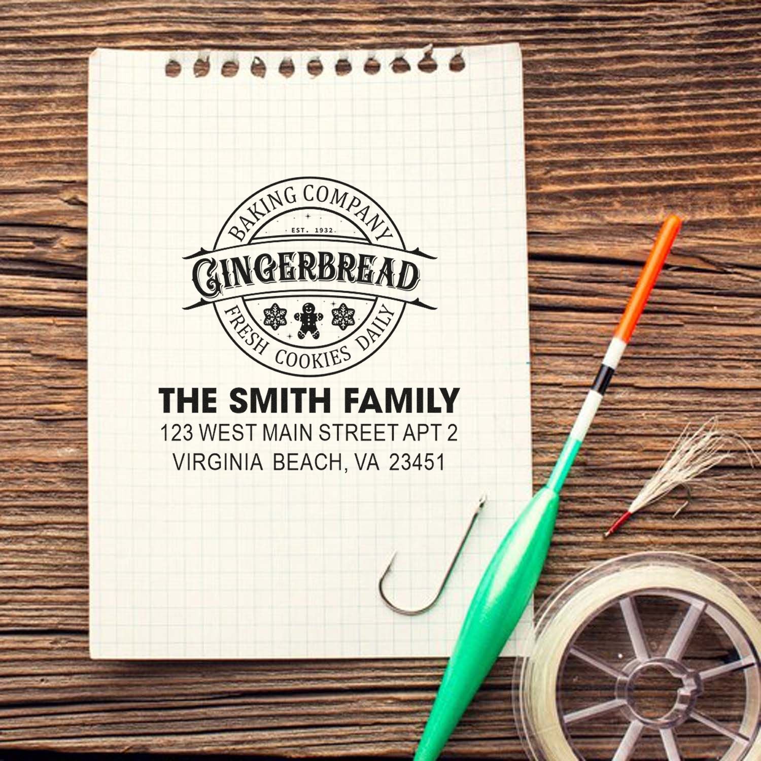 Custom gingerbread bakery rubber stamp with personalized return address for The Smith Family on a notebook mockup.