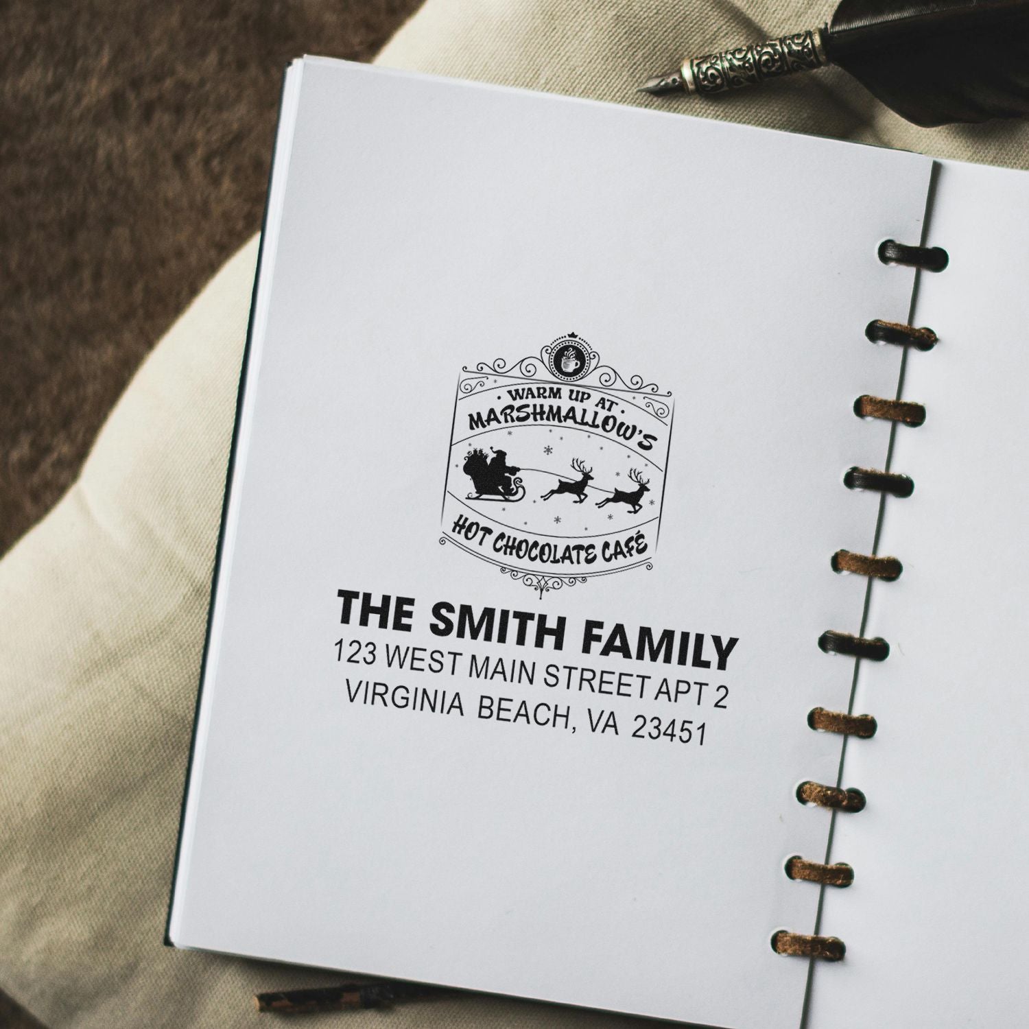 Personalized rubber stamp impression with family name and address on notebook page, showcasing a custom address stamp design.