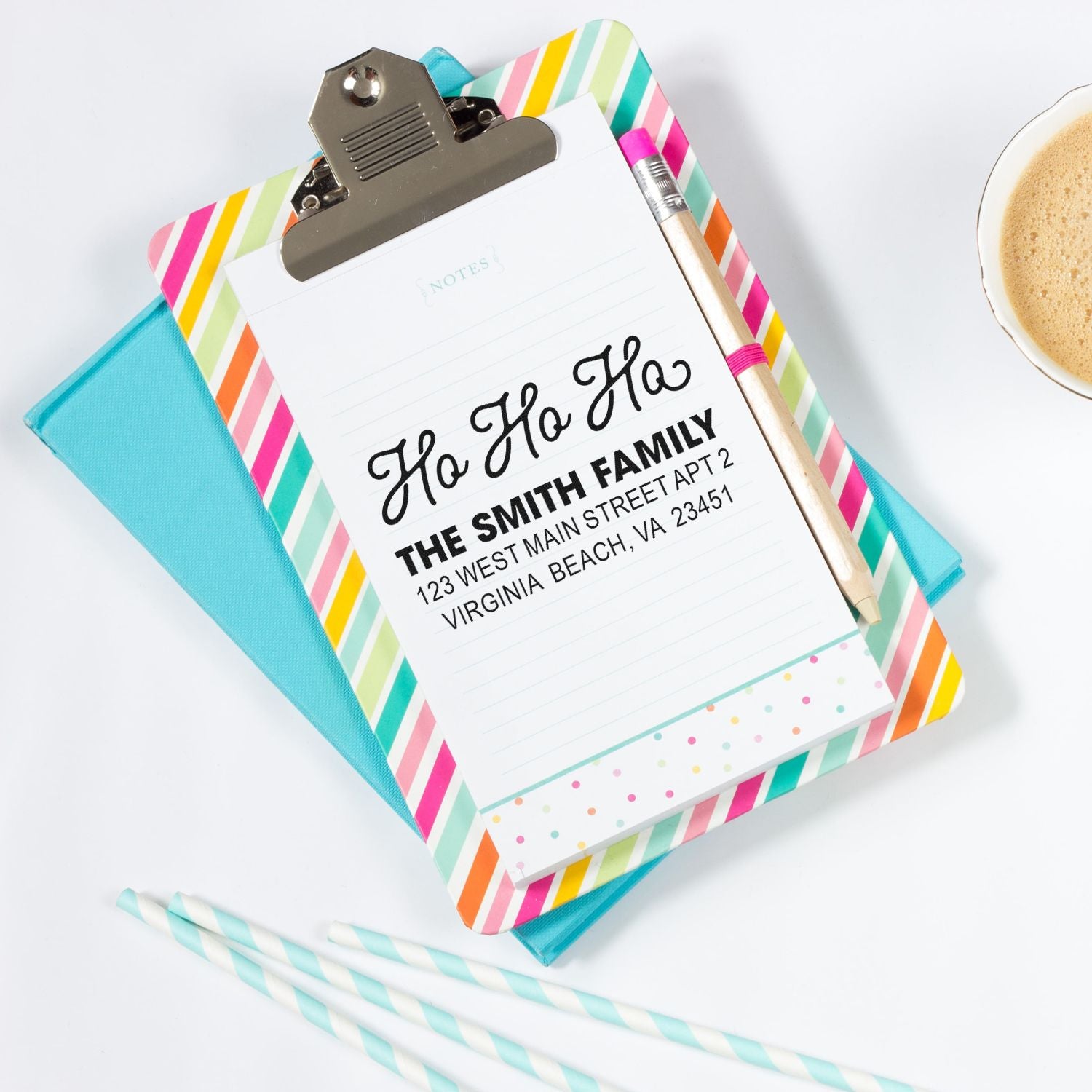 Custom holiday return address rubber stamp with Ho Ho Ho design on a festive clipboard and stationery.