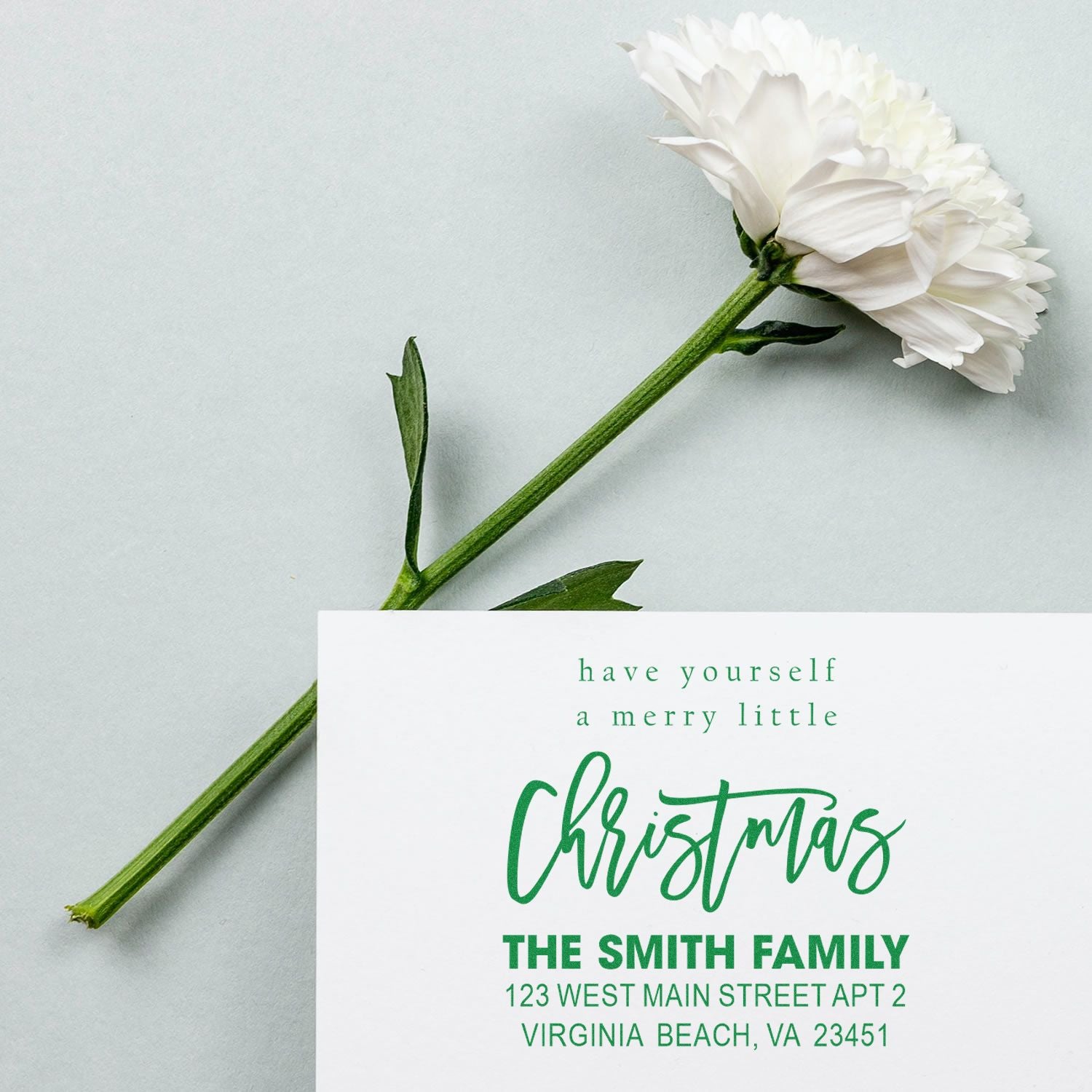 Personalized Christmas rubber stamp for holiday cards, featuring family name and return address.